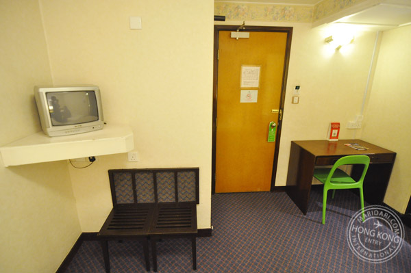 Evergreen Hotel Hong Kong no-window twin bedroom - TV, writing desk, chair, bench, carpet